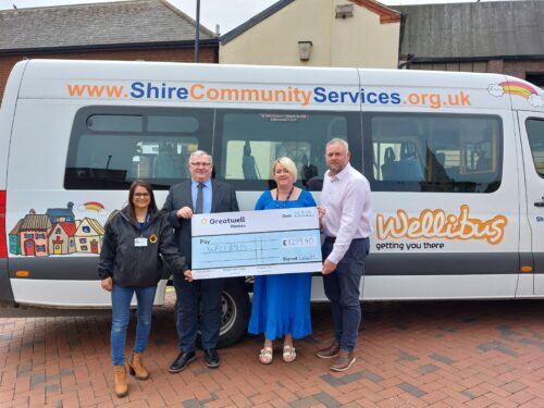 A picture of Greatwell Homes and Salvation Army Trading Company staff giving a cheque to Jonathan Ekins, MD of Shire Community Services who run Wellibus